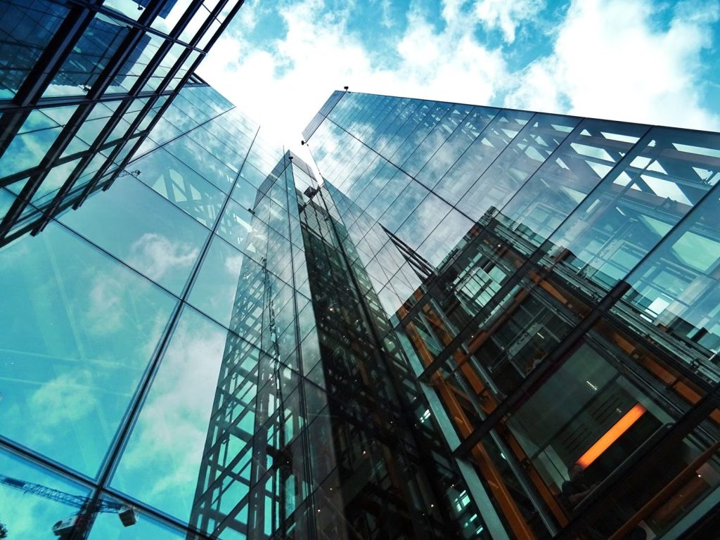 Fachadas acristaladas de edificios de oficinas vistas desde abajo contra un cielo azul